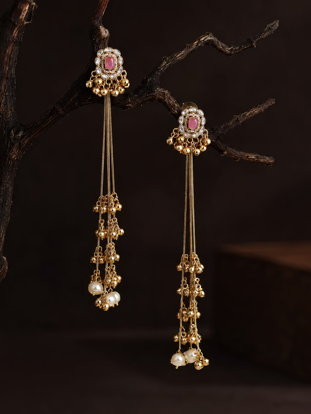 Gold earrings with gemstones and pearls on a dark background, Kashmiri Jhumka