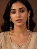 Woman wearing gold earrings with a plain background